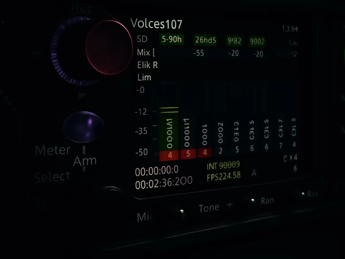 A sound mixer's hands adjusting the dials on a production audio mixer